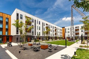A modern building with a courtyard in front.at Rowat Lofts, Des Moines Iowa   